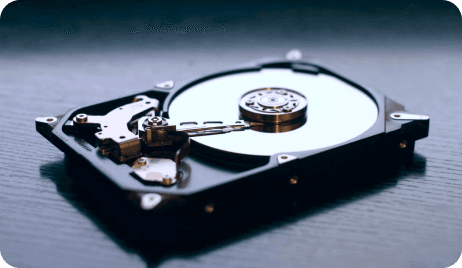 An open hard drive showing its spinning disk and read head